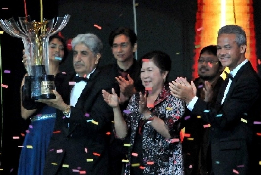 Produser film Sang Kiai Sunil Soraya (kiri) membawa Piala Citra untuk kategori film terbaik, disaksikan Menparekraf Mari Elka Pangestu (tengah) dan Gubernur Jateng Ganjar Pranowo (kanan), pada Malam Penganugerahan Festival Film Indonesia (FFI) 2013 di Mari