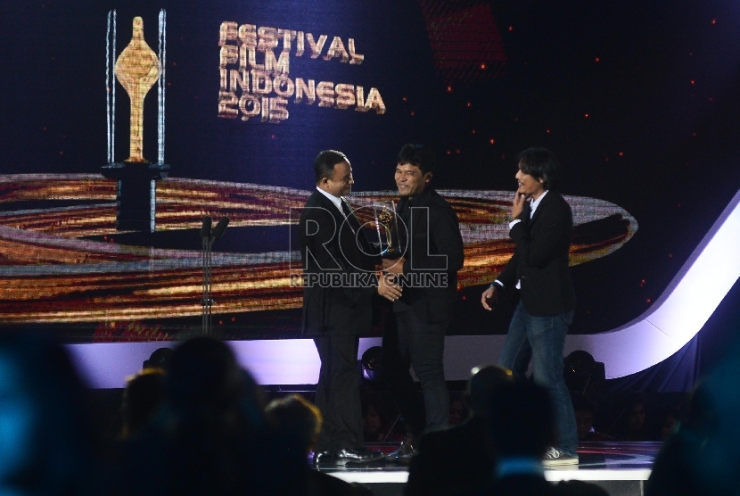   Produser film Siti Ifa Isfansyah (tengah) bersama Sutradara film Siti Eddie Cahyono (kanan) menerima piala citra yang diberikan oleh Menteri Pendidikan Anies Baswedan (kiri)dalam Malam Puncak Festival Film Indonesia (FFI) 2015, di Banten, Senin (23/11) m