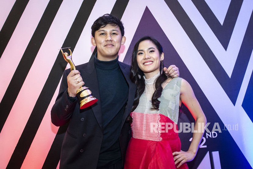 Produser musik Jevin Julian (kiri) dan penyanyi Sheryl Sheinafia (kanan) berpose dengan memegang piala penghargaan pada Malam Anugerah Musik Indonesia (AMI) 2019 di Jakarta, Rabu (27/11/2019). Jevin merilis single terbarunya, Bonfire.