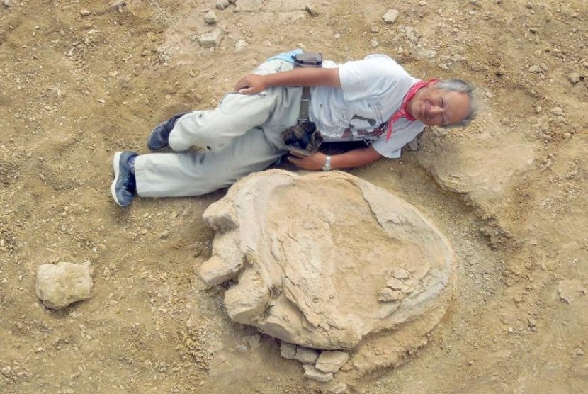 Profesor Shinobu Ishigaki berpose di dekat jejak kaki terbesar dinosaurus 