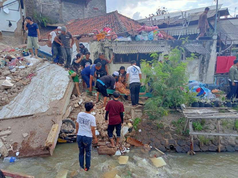 Proses evakuasi warga tertimpa bangunan roboh akibat gempa di Kampung Warungkondang RT 05 RW 01 Desa Jambudipa, Kecamatan Warungkondang, Kabupaten Cianjur, Senin (21/11/2022). Korban atas nama Ibu Emy (50) berhasil dievakusi warga.