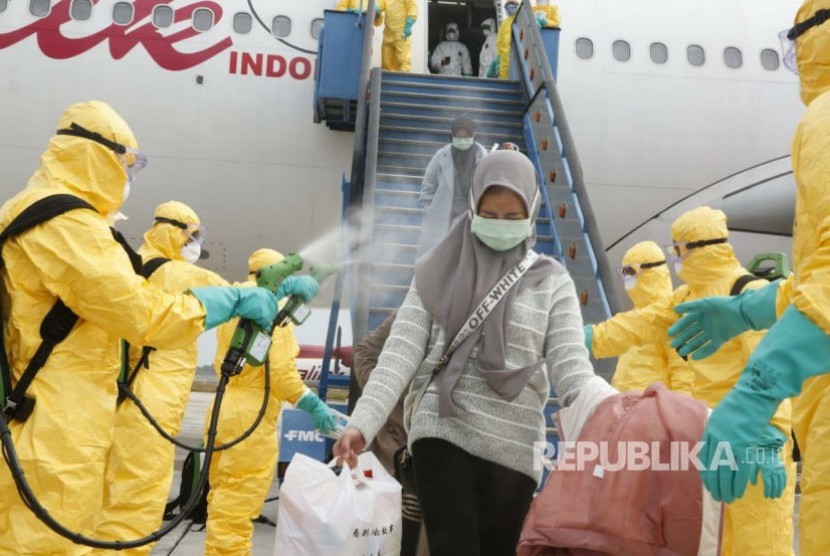 Proses evakuasi WNI dari Wuhan disemprot cairan desinfektan sesaat setelah turun dari pesawat Boeing A330-300 Batik Air di Bandara Internasional Hang Nadim Batam, Ahad (2/2).