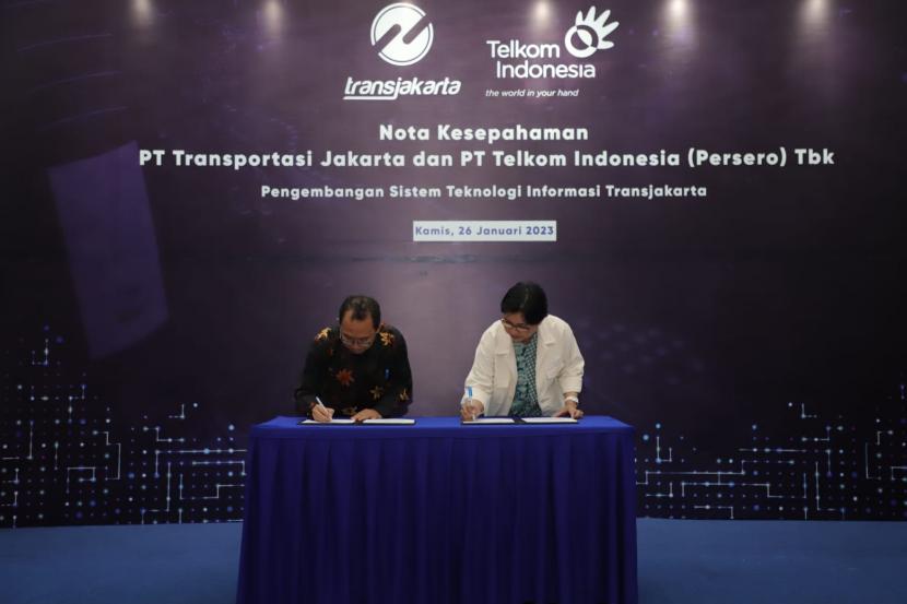 Proses penandatanganan nota kesepahaman kerja sama Telkom dan Transjakarta oleh PLT Direktur Enterprise and Business Service Telkom FM Venusiana R. (kanan) dan Direktur Utama Transjakarta M. Kuncoro Wibowo (kiri) pada Kamis (26/1/2023).