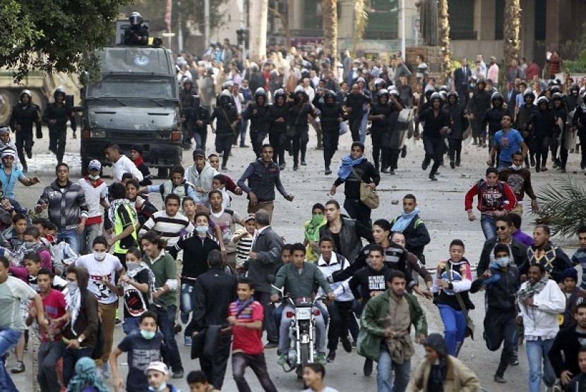 Protesters flee during clashes with police near Tahrir Square in Cairo November 28, 2012. Hundreds of demonstrators were in Cairo's Tahrir Square for a sixth day on Wednesday, demanding that President Mohamed Mursi rescind a decree they say gives him dictatorial powers, while two of Egypt's top courts stopped work in protest.   