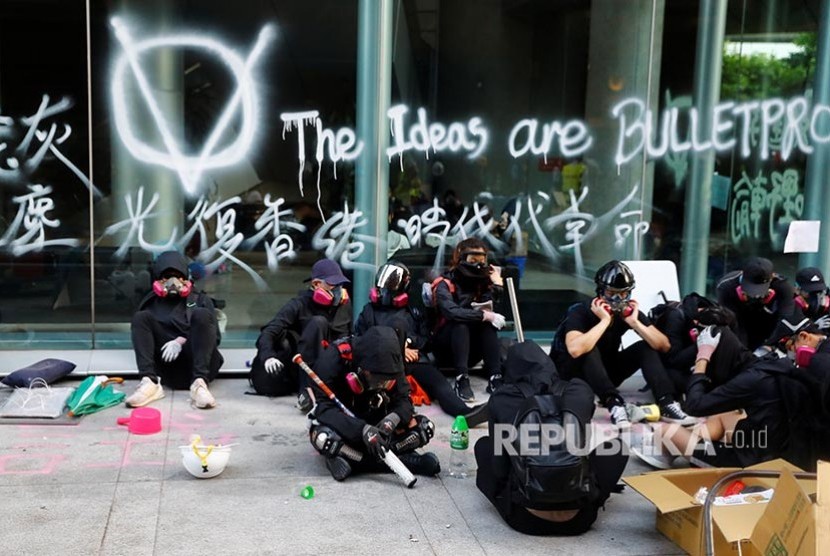 Mahasiswa beristirahat di area kampus Hong Kong Polytechnic University. Polisi mengepung kampus dengan ratusan mahasiswa pengunjukrasa di dalamnya.