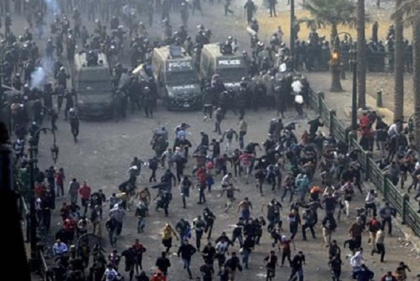 Protesters run from the riot police during clashes at Tahrir square in Cairo November 25, 2012. On Friday, President Mohamed Mursi had issued a decree widening his powers and shielding them from judicial review.  