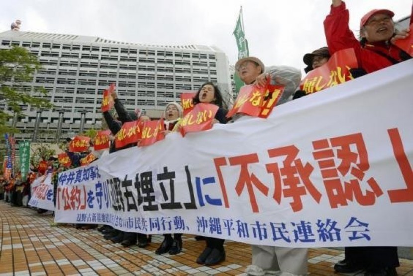 Protesters shout slogans during a rally against the relocation of a US military base, in front of the Okinawa prefectural government office building, in Naha on the Japanese southern islands of Okinawa, in this photo taken by Kyodo December 27, 2013.