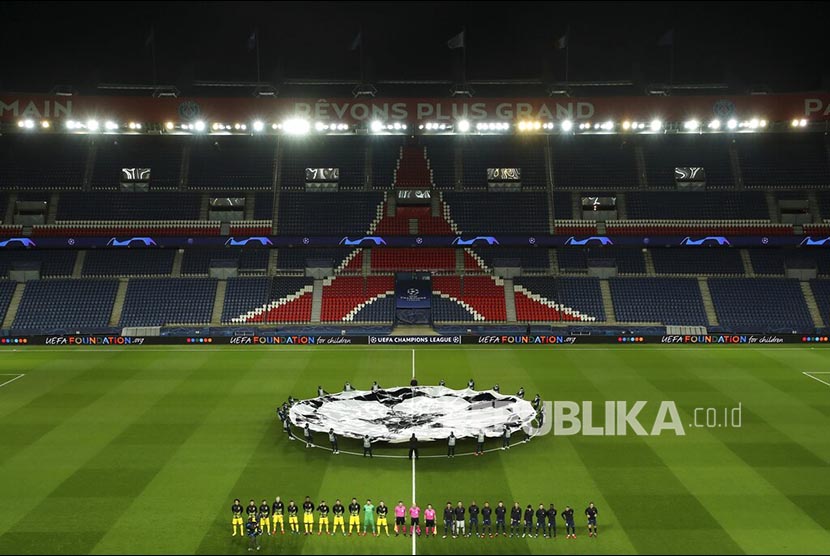 Para pemain PSG dan Borussia Dortmund berbaris menjelang laga di Parc de Princes Stadium, Perancis, Kamis (12/3).(UEFA via AP)