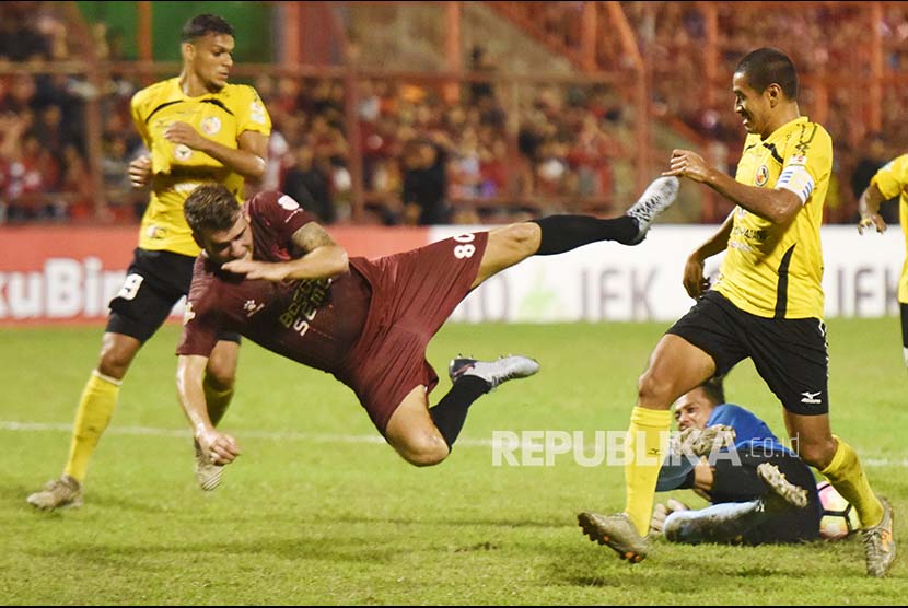 PSM Makassar Willem Jan Pluim (kiri) terjatuh ketika berebut bola dengan penjaga gawang Semen Padang FC Jandia Eka Putra (bawah) dan Hengki Ardiles (kanan) saat bertanding pada  Gojek  Traveloka Liga 1 di Stadion Andi Mattalatta, Makassar, Sulawesi Selatan, Senin (2/10). PSM Makassan menang atas tamunya, Semen Padang FC, dengan skor 4-0 