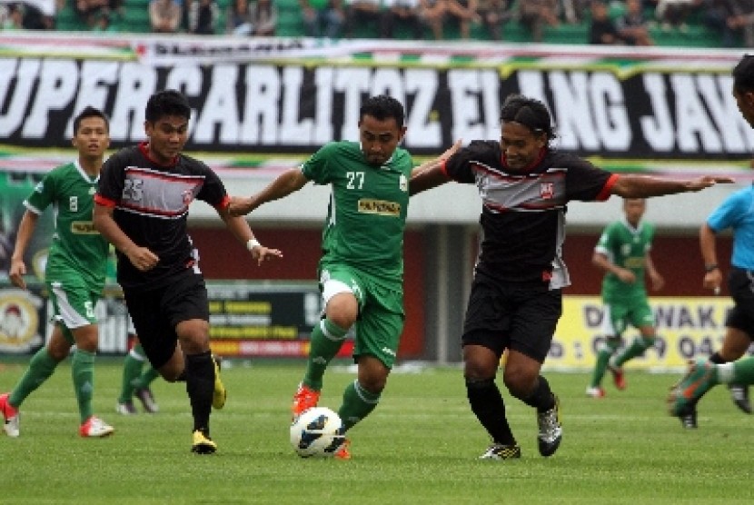 PSS Sleman, Fajar Listyantoro (tengah) berebut bola dengan dua pesepakbola Persis Solo, Diva Tarkas (kiri) dan Haryadi Putul (kanan)