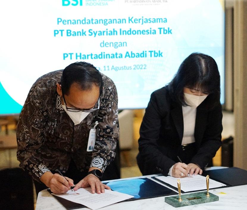 PT Hartadinata Abadi Tbk (HRTA) Sandra Sunanto (kanan) menandatangani kesepakatan kerja sama transaksi pembelian emas batangan dengan PT Bank Syariah Indonesia Tbk (BSI) di Jakarta,  Kamis (11/8/2022).