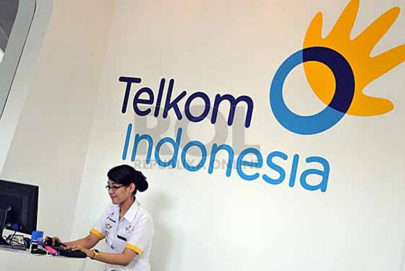 A staff works with logo of PT Telkom Indonesia on the wall behind in Jakarta. (file photo)