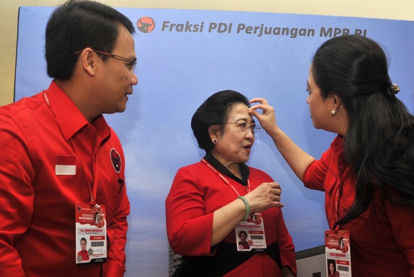 Puan Maharani (kanan) menyeka keringat di dahi ibunya yang juga Ketua Umum PDI Perjuangan Megawati Soekarnoputri (tengah) disaksikan Wakil Sekretaris Jenderal Dewan Pimpinan Pusat PDIP Ahmad Basarah (kiri) saat melihat-lihat stan berisi kiprah fraksi PDIP 