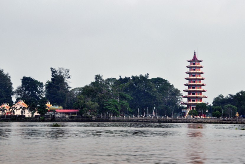 Pulau Kemaro yang terletak di tengah Sungai Musi dengan Pagoda dan wihara tempat beribadah umat Tridharma di bagian tengah.