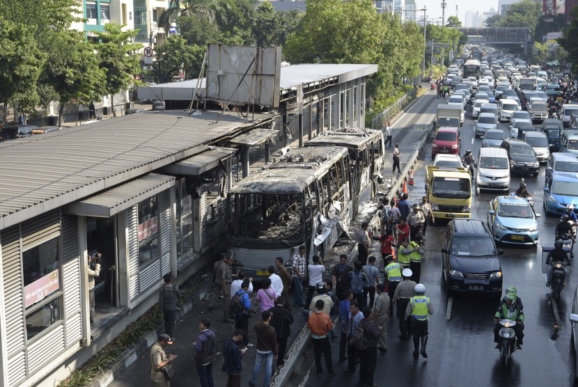 Puluhan kendaraan melintas di samping Bus Transjakarta yang terbakar di Halte Universitas Indonesia (UI) Salemba, Jakarta, Jumat (3/7). 