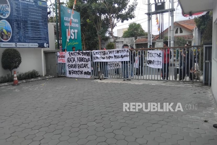 Puluhan mahasiswa dari Aliansi Mahasiswa Universitas Sarjanawiyata Tamansiswa (UST) Yogyakarta menggelar aksi demonstrasi di depan Gedung Pusat Kampus UST Yogyakarta, Selasa (19/8/2025).