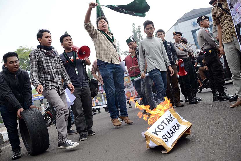 Puluhan mahasiswa yang tergabung dalam Himpunan Mahasiswa Islam (HMI) menggelar aksi membakar kotak suara dari kardus dalam aksi menyikapi Pemilu 2014 di perempatan Cikapayang, Kota Bandung, Kamis (27/2).