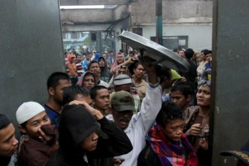 Puluhan narapidana berada di sekitar pintu gerbang Lapas Klas II A Labuhan Ruku pasca kerusuhan yang terjadi di lapas itu, Kabupaten. Batubara, Sumut, Senin (19/8).