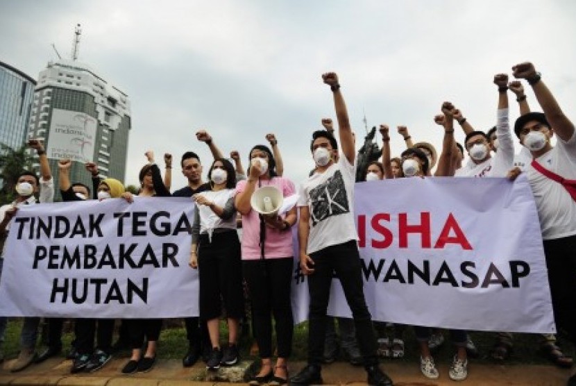 Puluhan pegiat seni melakukan aksi menolak asap dengan menggunakan masker di Patung Kuda, Jakarta, Jumat (9/10). 