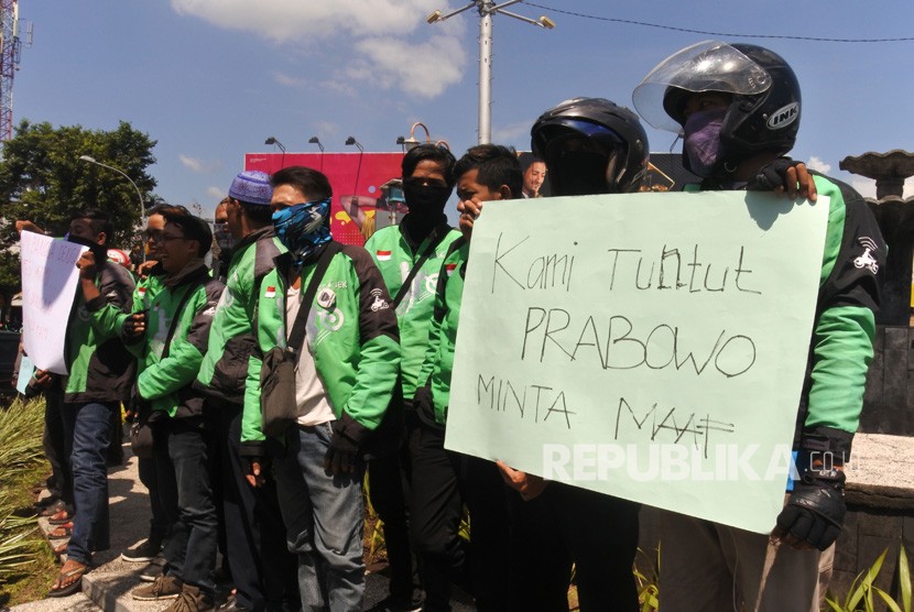 Puluhan pengemudi ojek daring melakukan aksi demo di Bundaran DPRD Jember, Jawa Timur, Jumat (23/11/2018).