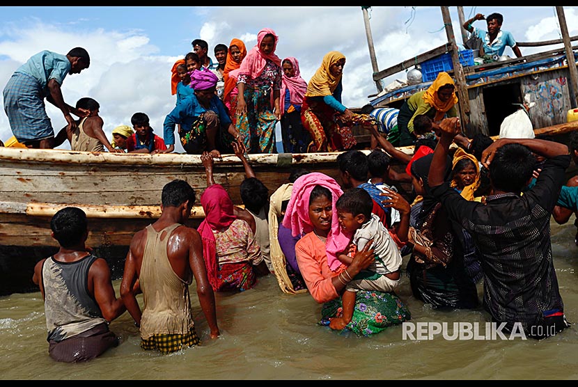 Puluhan pengungusi Rohingya turun dari perahu setibanya di pesisir Teluk Bengal, di Shah Porir Dwip, Bangladesh, Selasa (11/9)