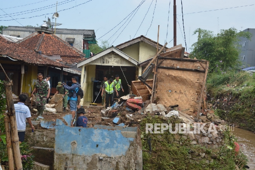  Puluhan rumah di dua desa dan satu kelurahan di Kecamatan Cicurug, Kabupaten Sukabumi rusak diterjang banjir, Selasa (14/6) malam. Tampak, petugas tengah membersihkan material lumpur di rumah warga yang hancur. 