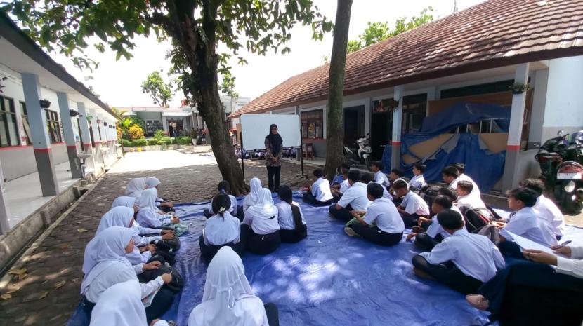 Puluhan siswa SMP Negeri 60 Kota Bandung di Jalan Cisereuh belajar di luar ruangan