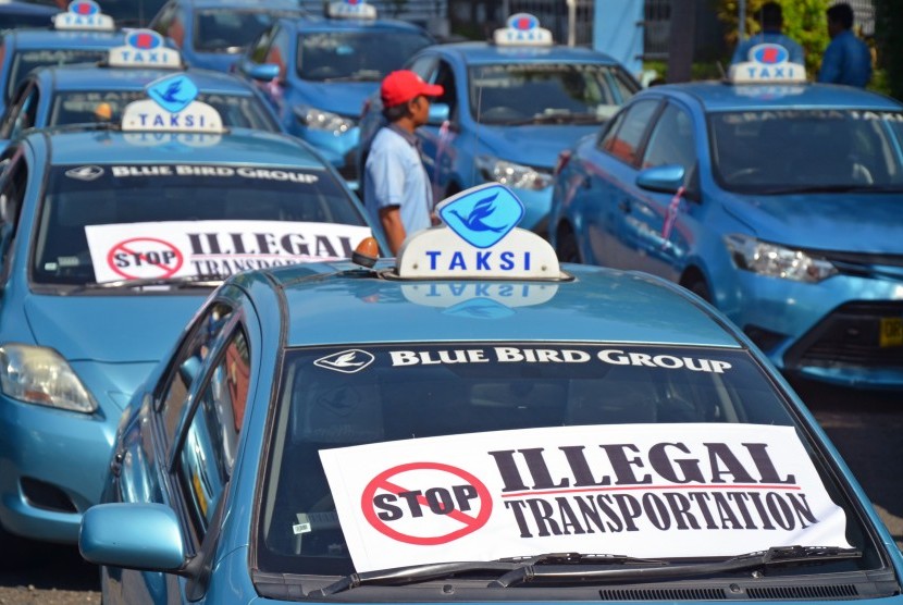 Puluhan sopir taksi memarkir kendaraan mereka saat melakukan unjuk rasa di kantor Dishubkominfo Provinsi NTB, di Mataram, Rabu (23/3). 