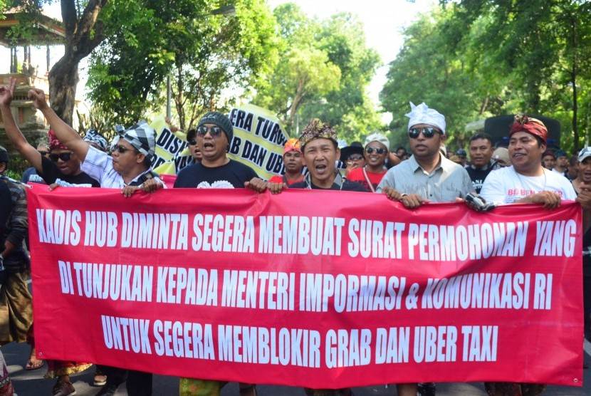 Puluhan sopir transportasi konvensional melakukan aksi unjuk rasa di kawasan Renon, Denpasar, Bali, Rabu (23/3).