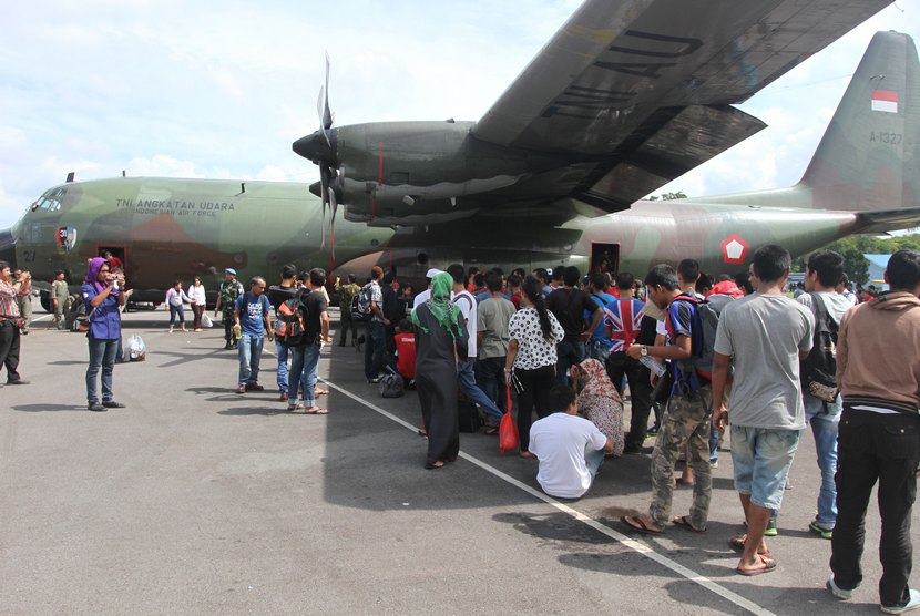  Puluhan TKI berada di sekitar pesawat Hercules ketika akan didata setibanya di Lanud Soewondo, Medan, Sumut, Rabu (24/12). (Antara/Irsan Mulyadi)