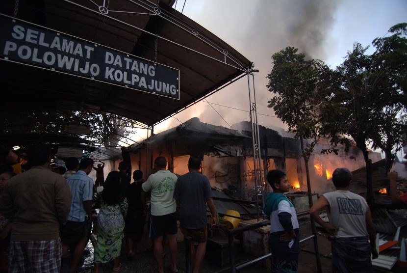 Sejumlah pedagang berusaha mengeluarkan barang dagangan mereka saat terbakarnya Pasar Cik Puan Pekanbaru, Riau, Senin malam (6/7). 