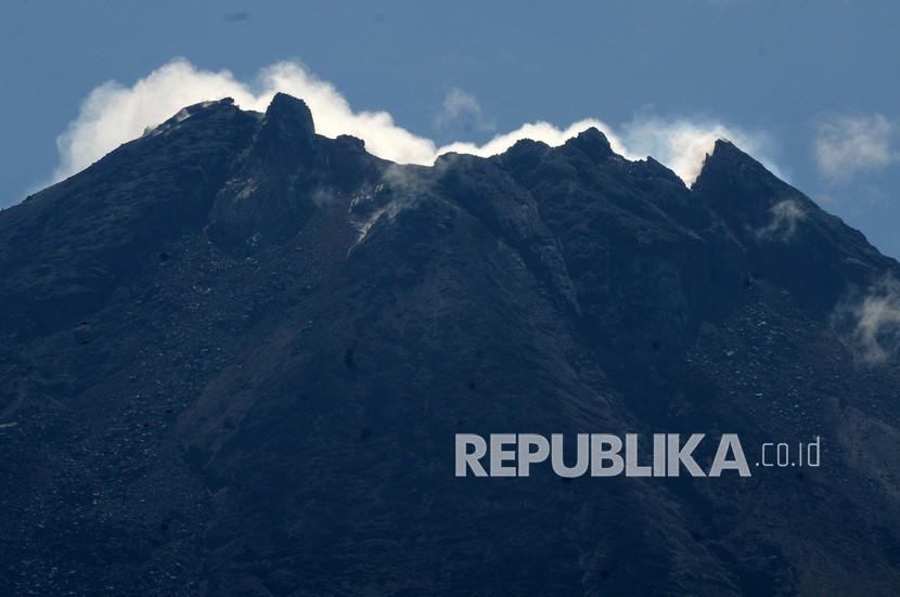 Puncak Gunung Merapi yang mengeluarkan asap putih terlihat dari wilayah Tlogolele, Selo, Boyolali, Jawa Tengah, Selasa (8/12/2020). Berdasarkan data pengamatan Balai Penyelidikan dan Pengembangan Teknologi Kebencanaan Geologi (BPPTKG) periode (7/12/2020) jumlah kegempaan guguran 49, fase banyak 192, vulkanik dangkal 23, hembusan 29, tektonik satu, serta laju deformasi Gunung Merapi EDM Babadan sebesar 11 cm per hari. 