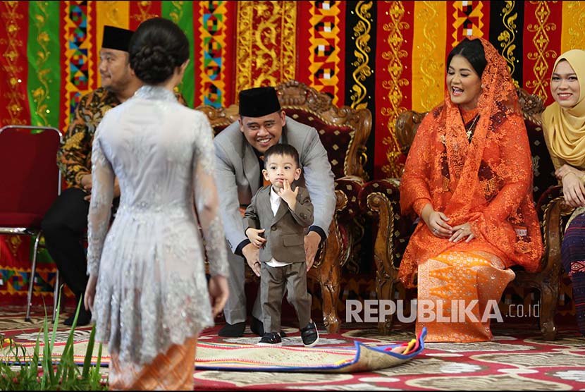 Putri Presiden Joko Widodo, Kahiyang Ayu (kedua kanan) bersama suaminya Bobby Afif Nasution memegang Ethes anak Gibran Rakabuming di sela ritual adat 