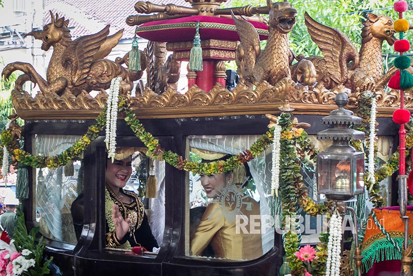 Putri Presiden Joko Widodo, Kahiyang Ayu, melambaikan tangan saat naik kereta kencana menuju acara ijab dan resepsi pernikahan di Graha Saba Buana, Solo, Jawa Tengah, Rabu (8/11).