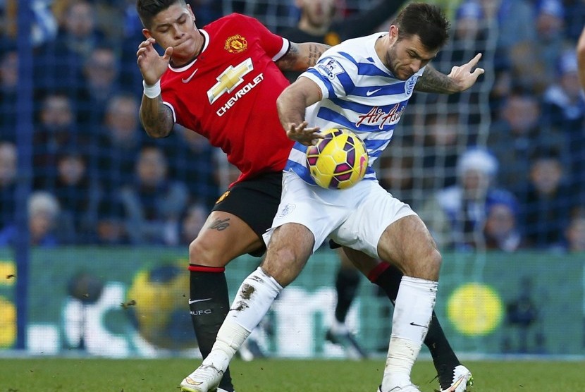 Queens Park Rangers' Charlie Austin (R) is challenged by Manchester United's Marcos Rojo during their English Premier League soccer match, at Loftus Road in London January 17, 2015