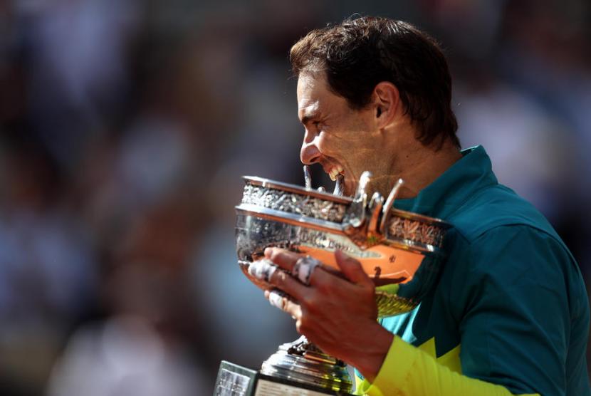 Rafael Nadal memegang trofi juara French Open 2022.