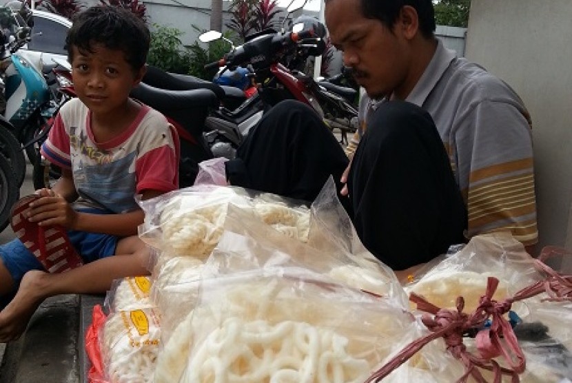 Rahmat (11 tahun) membantu ayahnya, Ade Djunaedi (35) yang tunanetra menjual kerupuk ikan. Mereka menjual kerupuk SPBU Pondok Pinang, Jakarta Selatan.