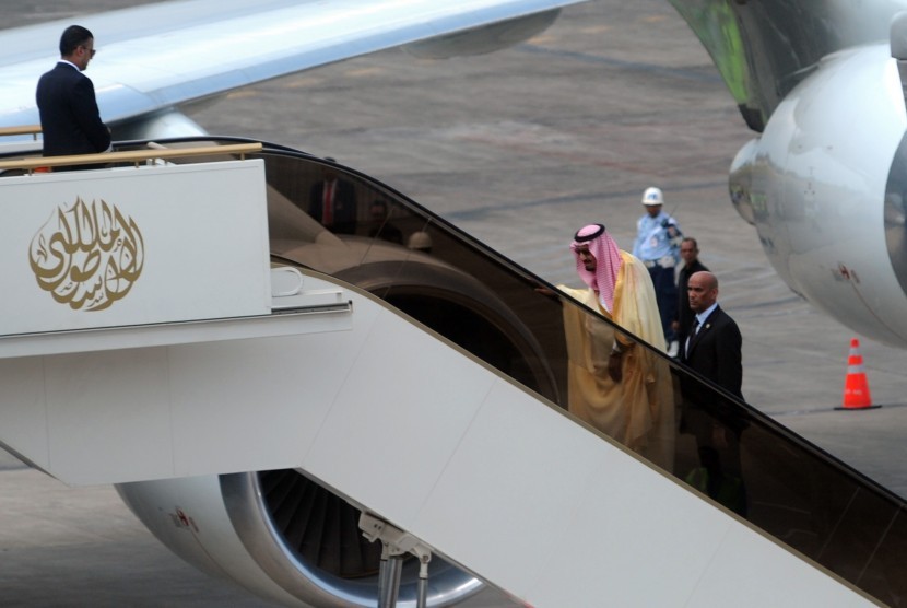 Raja Arab Saudi Salman bin Abdulaziz al-Saud (kedua kiri) menaiki pesawat di Bandar Udara I Gusti Ngurah Rai, Bali, Ahad (12/3). 
