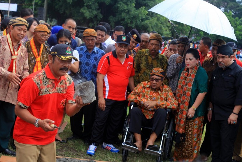 Raja Keraton Kasunanan Surakarta Hadiningrat Pakubowono XIII (duduk di kursi roda) menyaksikan prosesi simbolik peletakan batu pertama pembangunan Pasar Darurat Klewer oleh Walikota Solo, Fx Hadi Rudyatmo (kiri) di Alun-alun Utara keraton setempat, Solo, Jawa Tengah, 6 April 2015. 