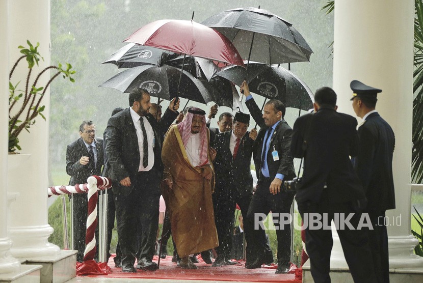 Raja Salman dan Presiden Joko Widodo berjalan di bawah payung saat hujan deras di Istana Bogor,  Rabu (1 /3).