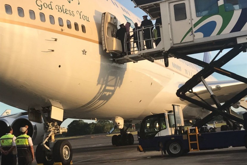 Raja Salman keluar dari pesawat di bawah pengawalan Brigadir Jenderal Abdulaziz Al-Faghm, pengawal pribadinya. Raja Salman akan berlibur 4-9 Mafet 2017 di Bali.  