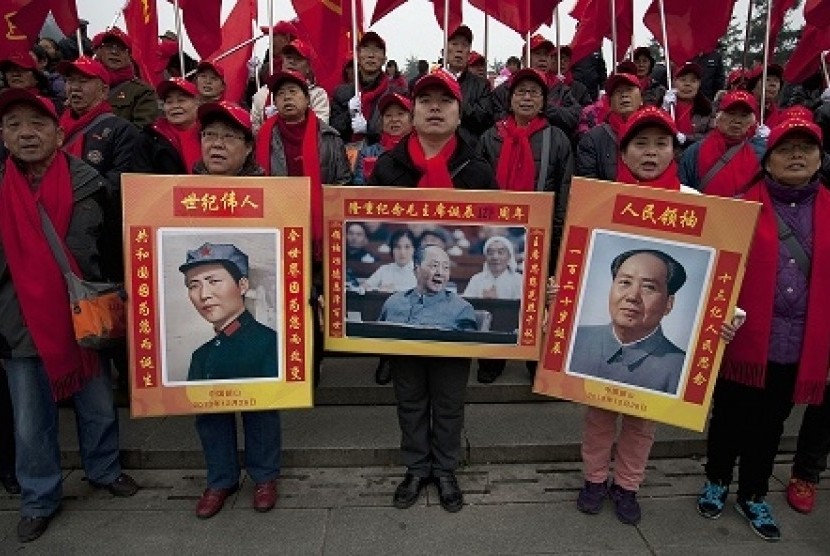 Rakyat Cina mengangkat poster mantan ketua Partai Komunis Mao Zedong.