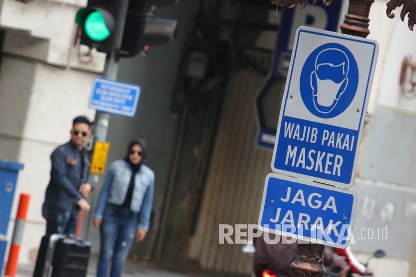Rambu Wajib Pakai Masker dan Jaga Jarak terpasang di tiang lampu di Jalan Tunjungan, Surabaya, Jawa Timur, Sabtu (6/6/2020). Pemerintah Kota Surabaya memasang rambu-rambu bertuliskan Wajib Pakai Masker dan Jaga Jarak itu di sejumlah ruas jalan dan tempat kumpul warga untuk meningkatkan kesadaran warga mematuhi protokol kesehatan pencegahan penularan COVID-19. 