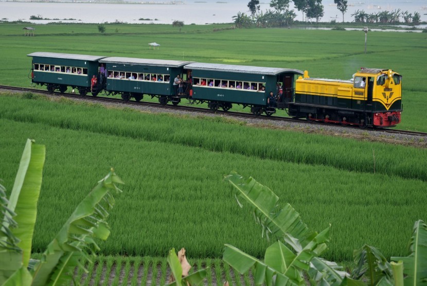 Rangkaian kereta api kuno membawa sejumlah wisatawan melintasi kawasan Rawa Pening di Bawen, Kabupaten Semarang, Jawa Tengah, Minggu (16/4). 