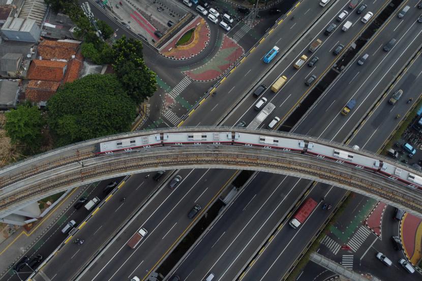 Rangkaian kereta Light Rail Transit melintasi jembatan lengkung di Jakarta.