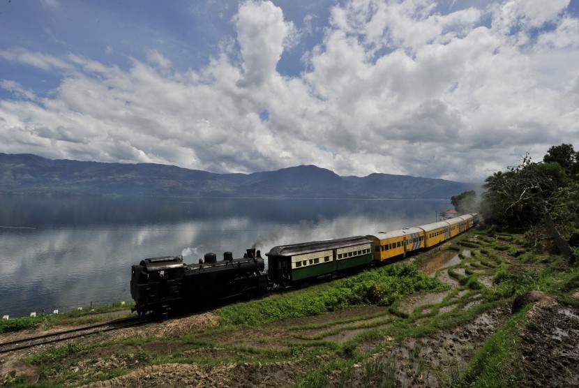 Rangkaian kereta yang ditarik lokomotif tua Mak Itam melaju di Sumatra Barat.