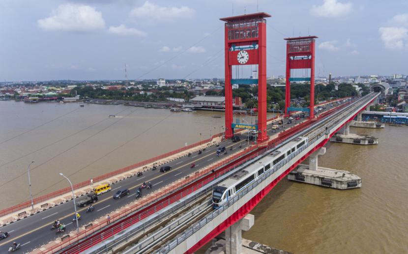 Rangkaian Light Rail Transit (LRT) melintas di atas Sungai Musi, Palembang, Sumatra Selatan, Selasa (30/3/2021).