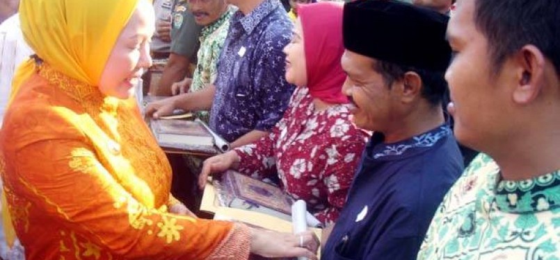 Ratu Atut Chosiyah (kiri), Gubernur Banten, membagikan Alquran Mushaf Al-Bantani kepada masyarakat. 