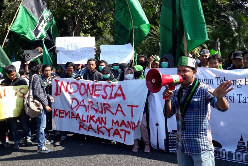 Ratusan anggota Himpunan Mahasiswa Islam (HMI) Surabaya menggelar aksi di depan Gedung Negara Grahadi Surabaya, Selasa (24/9). Mereka menuntut Presiden Jokowi menerbitkan Perppu untuk membatalkan Undang-Undang KPK yang dianggap melemahkan lembaga antirasuah tersebut.