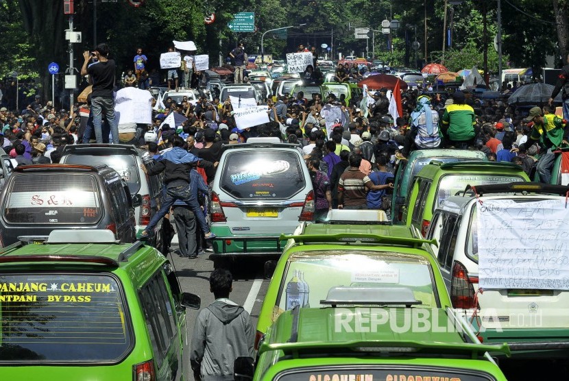 Ratusan angkot dan taksi di parkir di depan Gedung Sate pada aksi angkutan kota (angkot) dan taksi Kota Bandung melakukan aksi unjuk rasa dan mogok massal di depan Gedung Sate, Jalan Diponegoro, Kota Bandung, Kamis (9/3). 
